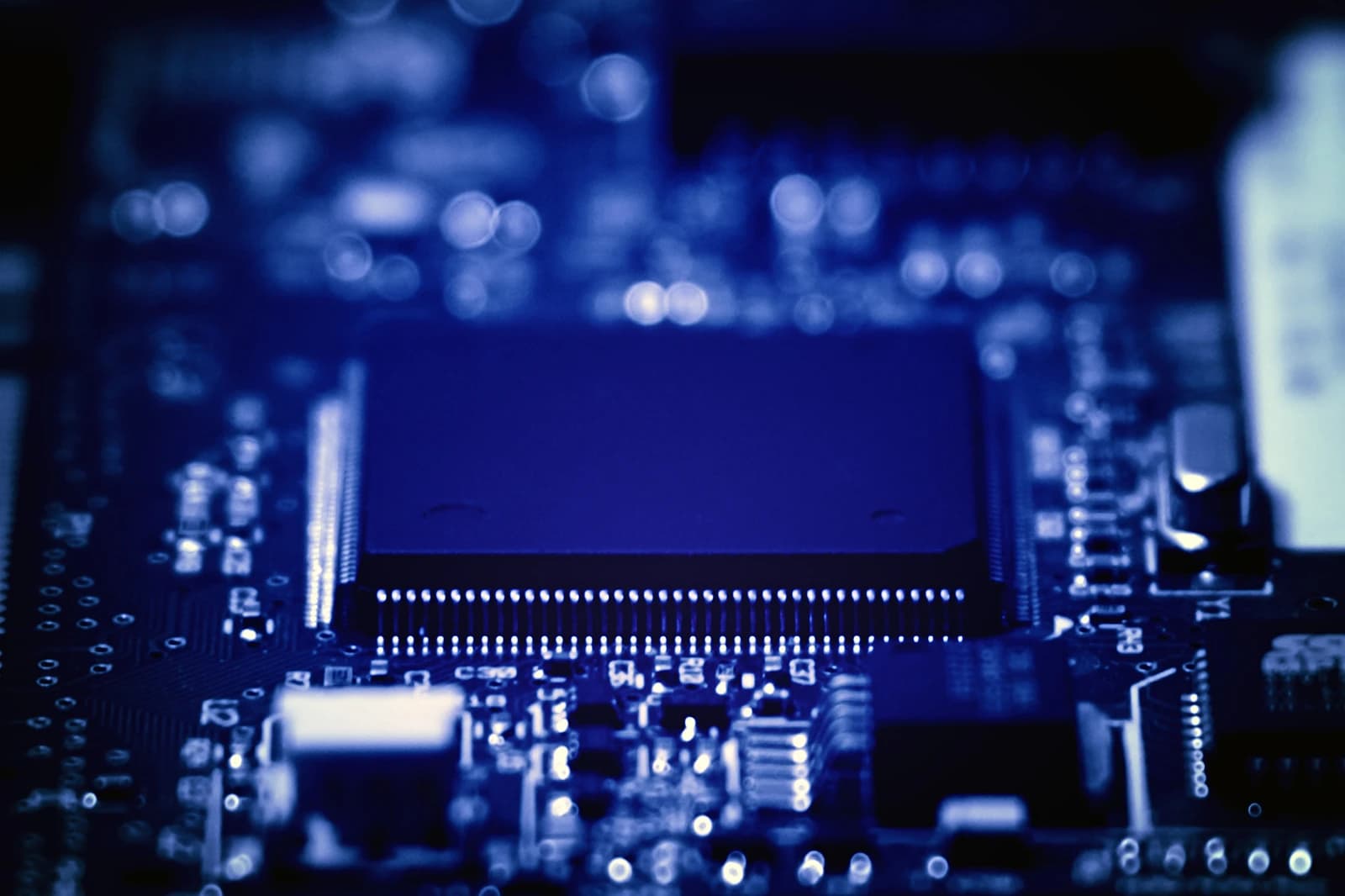 Close-up view of an electronic circuit board with a central microchip.