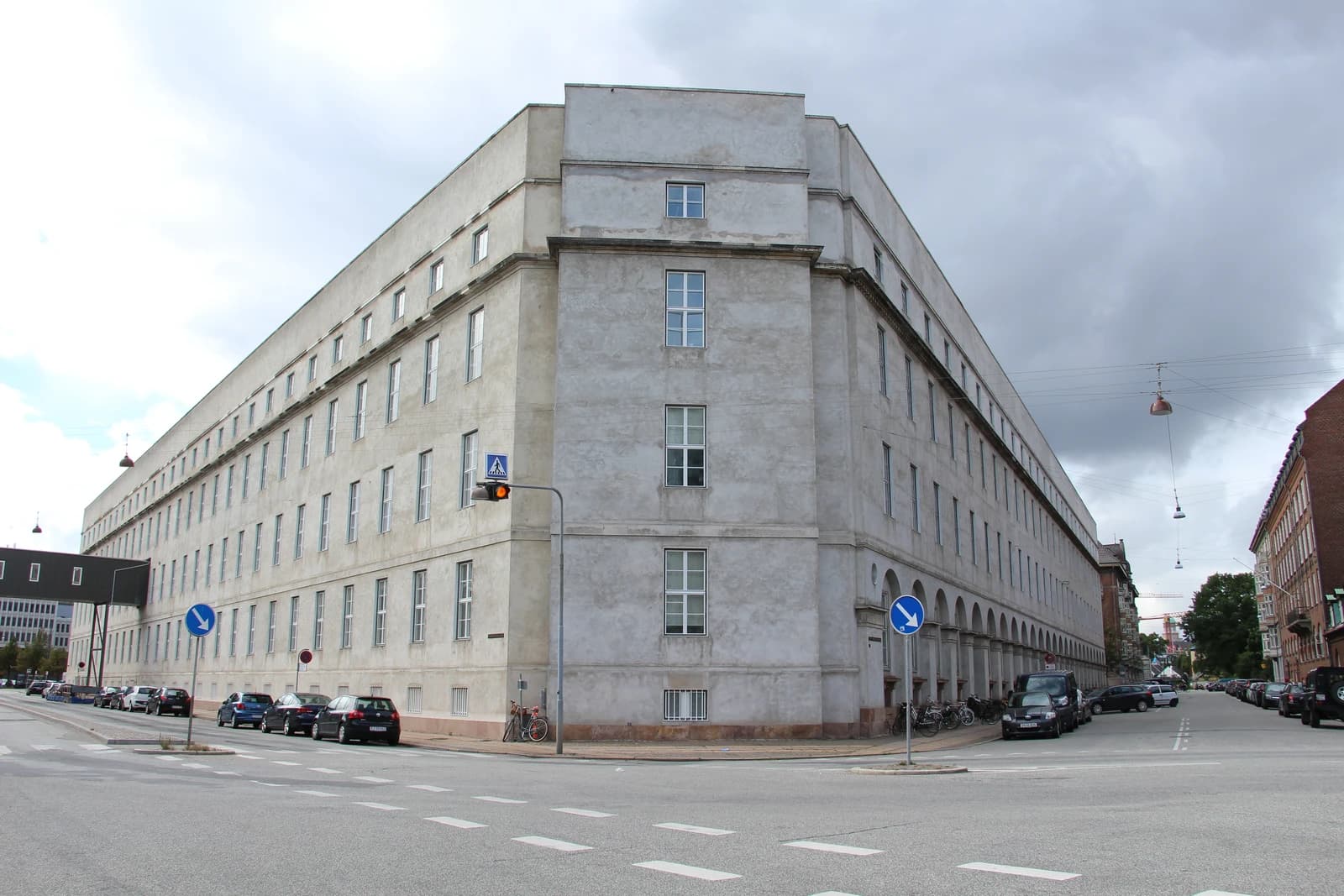 Copenhagen Police Headquarters building, a large concrete structure with many windows, viewed from a street corner.