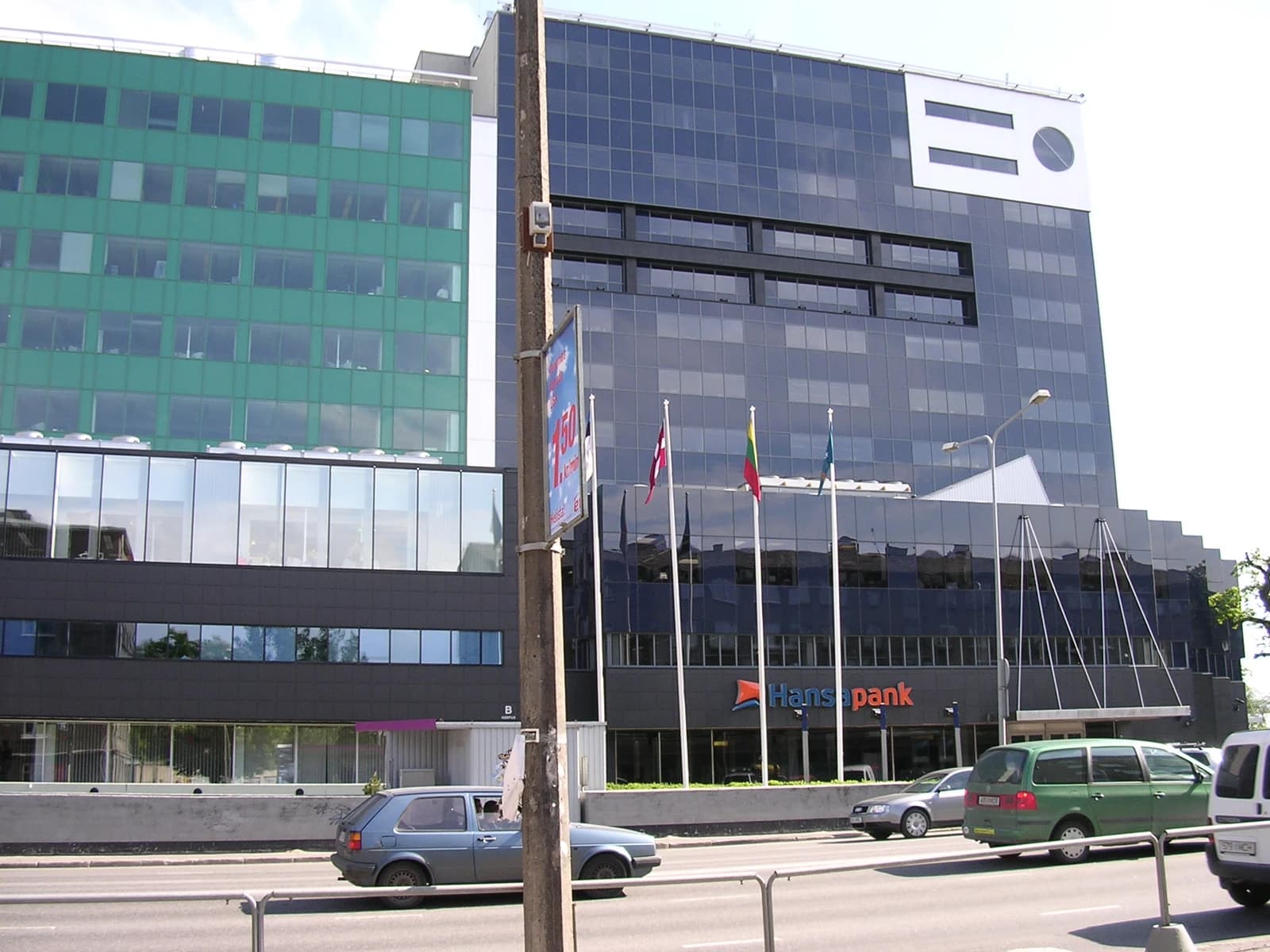 Hansabank headquarters building in a city, with flags and cars visible.