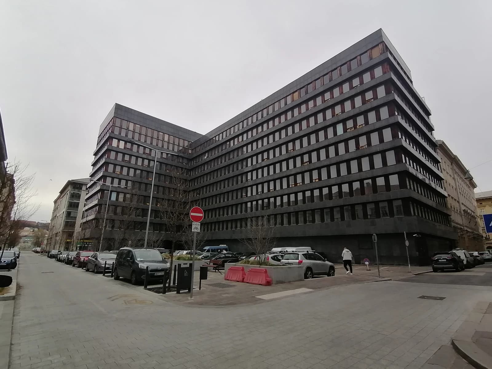 Exterior view of the dark, multi-story Országos Tervhivatal building in Hungary.
