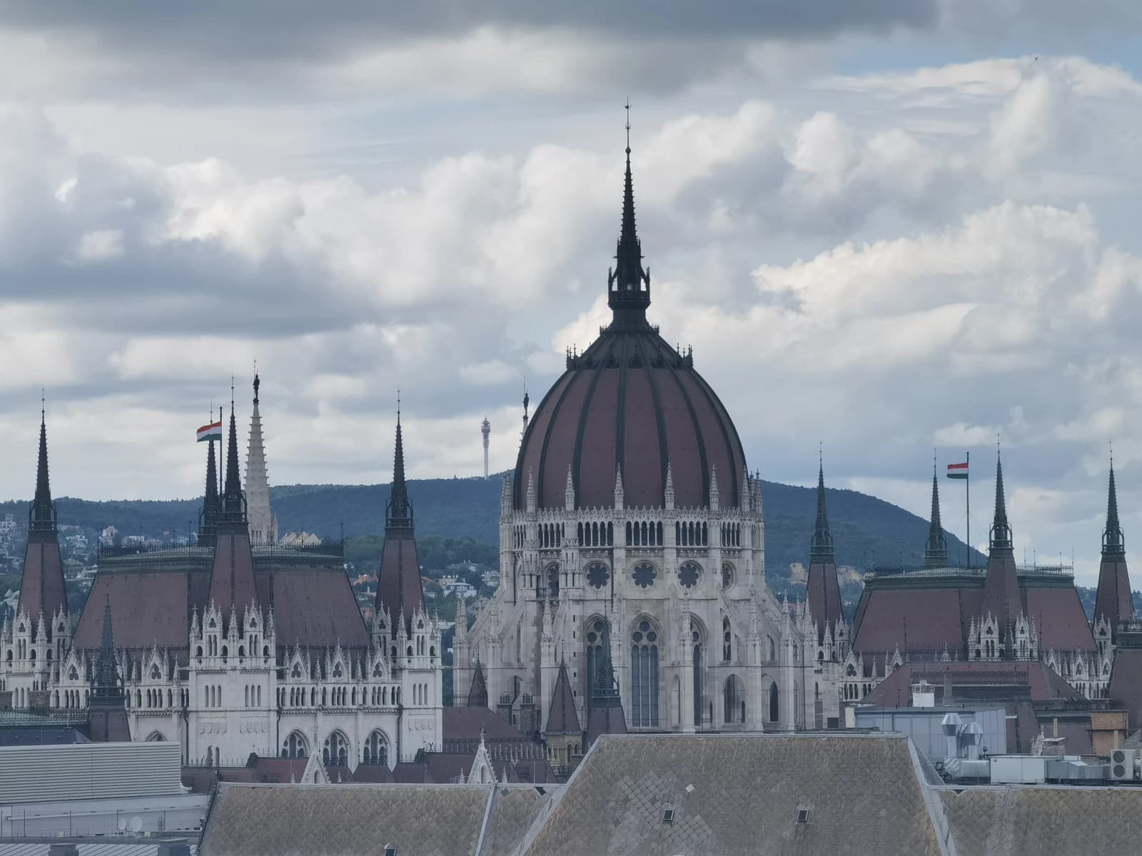 View of the Hungarian Parliament Building in Budapest with a cloudy sky.