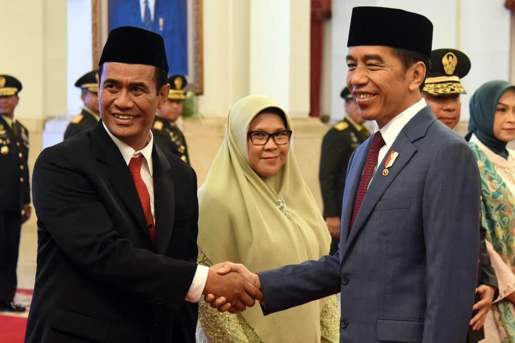 Indonesian President Joko Widodo shakes hands with newly appointed Agriculture Minister Amran Sulaiman.