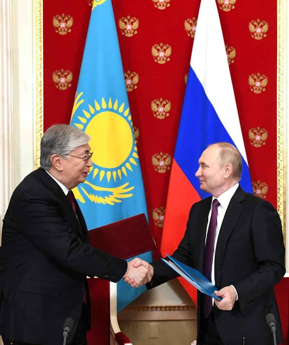 Kazakhstan President Kassym-Jomart Tokayev and Russian President Vladimir Putin shake hands at a meeting.