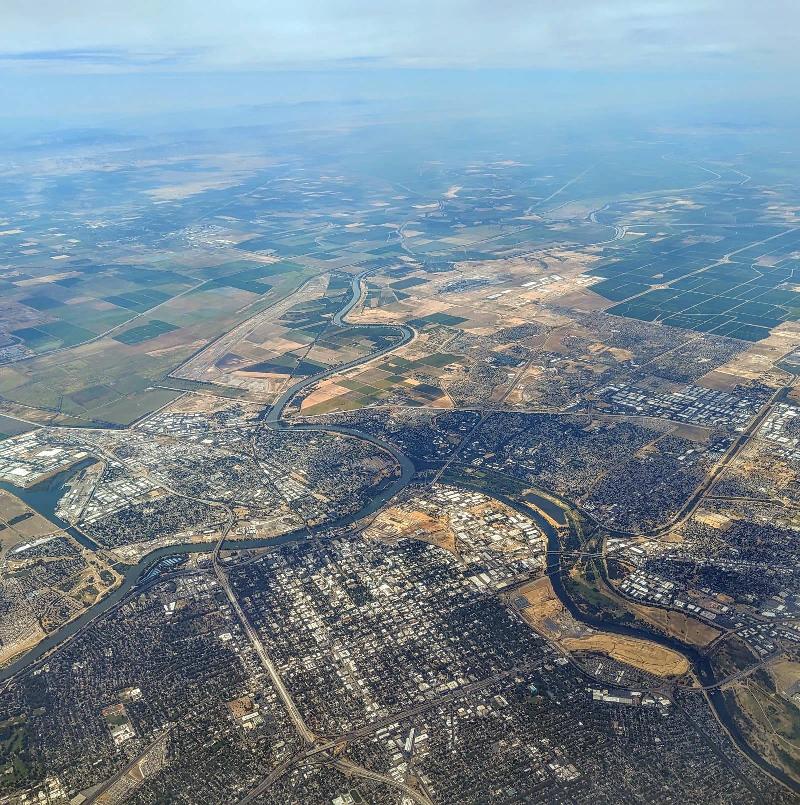 Aerial view showing the cityscape of Sacramento, California, with a river winding through it.