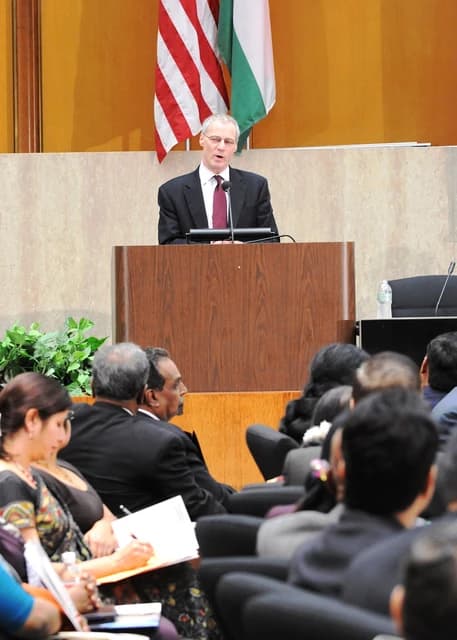 US-India Business Council President Ron Somers delivers remarks from a podium.