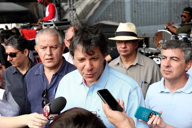 Fernando Haddad, Mayor, at Parque Tietê holding a smartphone.