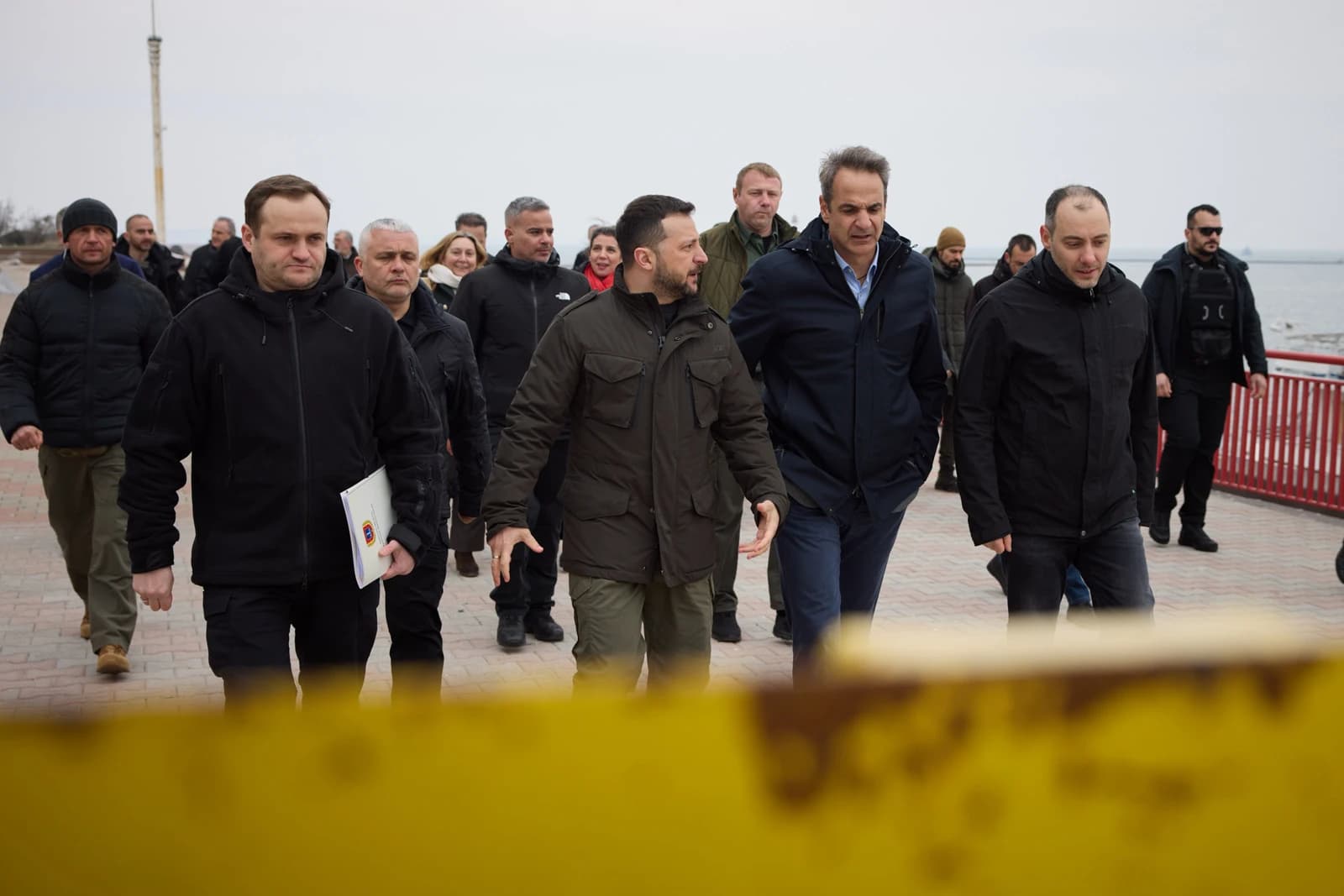 Volodymyr Zelenskyy and Kyriakos Mitsotakis walk with delegation in Odesa port.