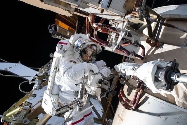 NASA astronaut Jessica Meir installs a roll-out solar array modification kit to the exterior of the International Space Station.