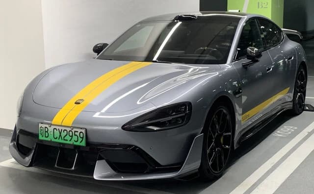 Gray Xiaomi SU7 Ultra electric car with a yellow racing stripe, license plate visible.