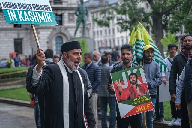 Kashmiri activist holds a sign reading "HUMAN RIGHTS VIOLATION IN KASHMIR" during a protest in London.