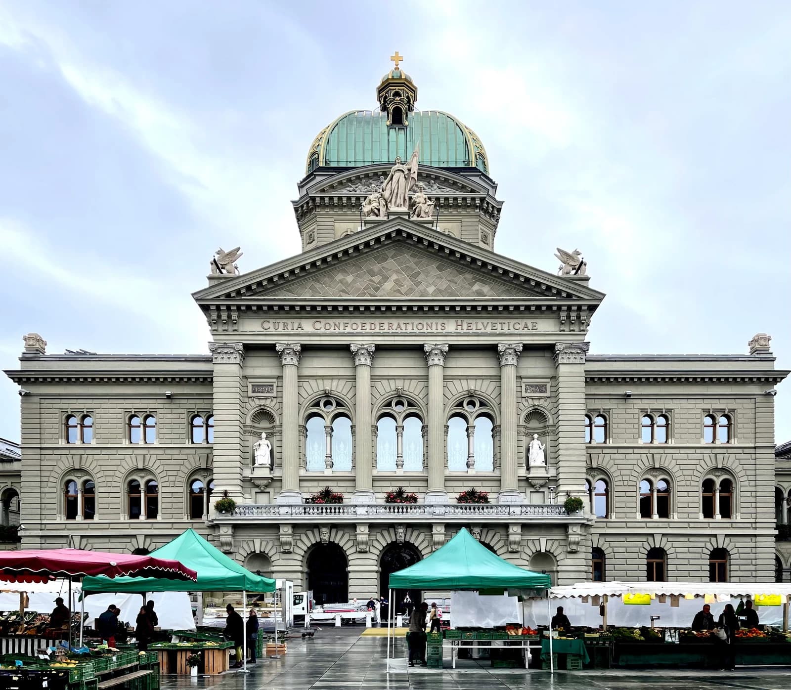 The Federal Palace of Switzerland, Bundeshaus, in Bern, under a cloudy sky.