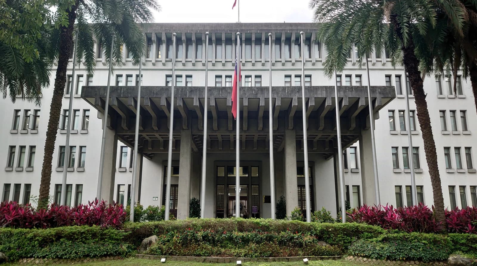 Exterior of the Ministry of Foreign Affairs building in Taiwan, with palm trees and a flag.