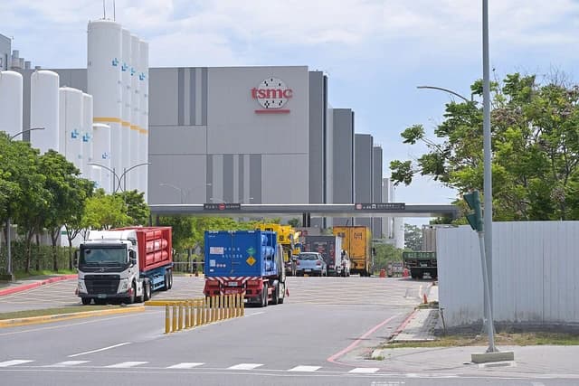 Trucks entering and leaving TSMC Fab 18 facility on a sunny day.