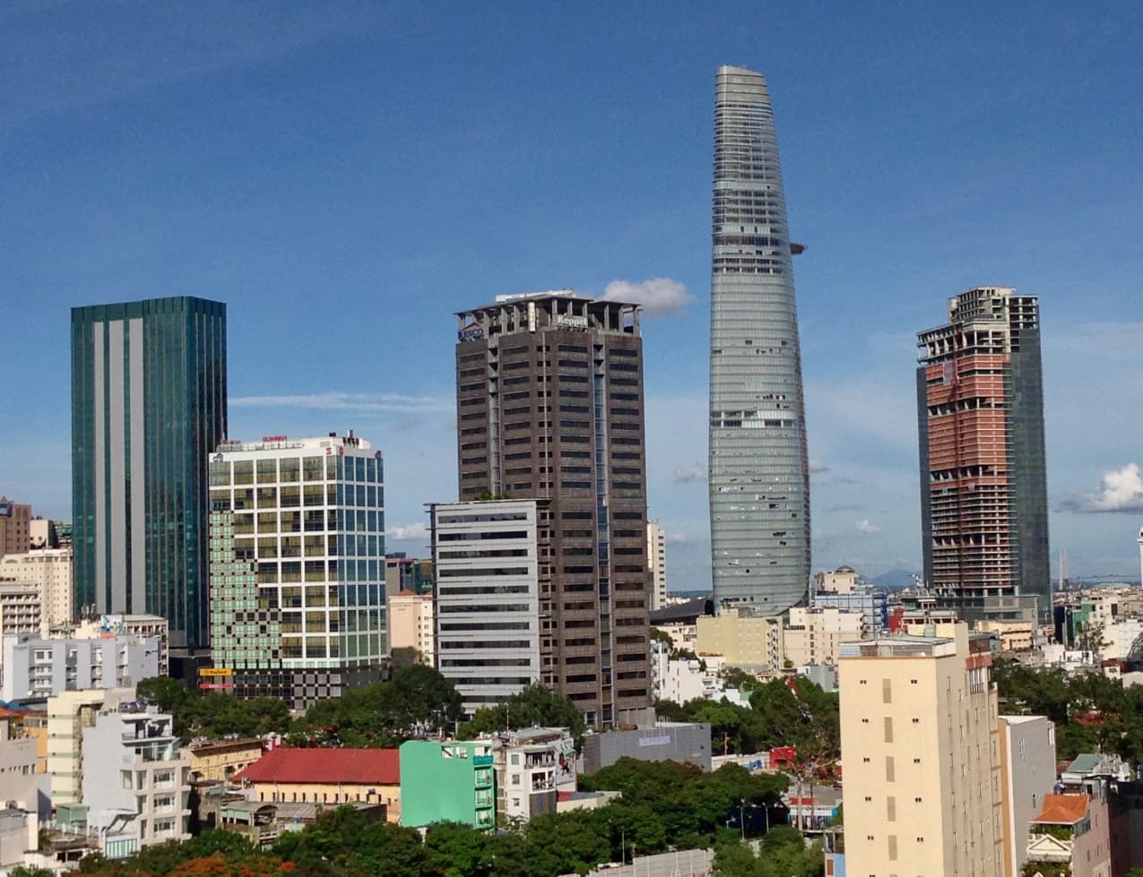 Skyscrapers of Ho Chi Minh City, Vietnam, including the Bitexco Financial Tower, under a clear sky.