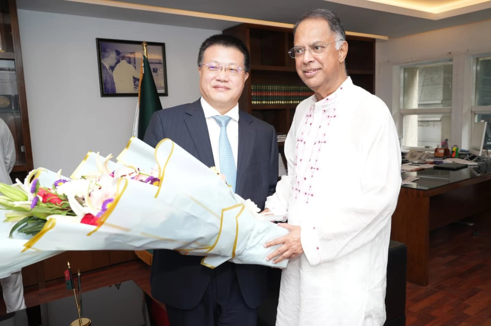 Yao Wen, China Ambassador, receiving flowers from Iqbal Hasan Mahmud, Bangladesh Power Minister.