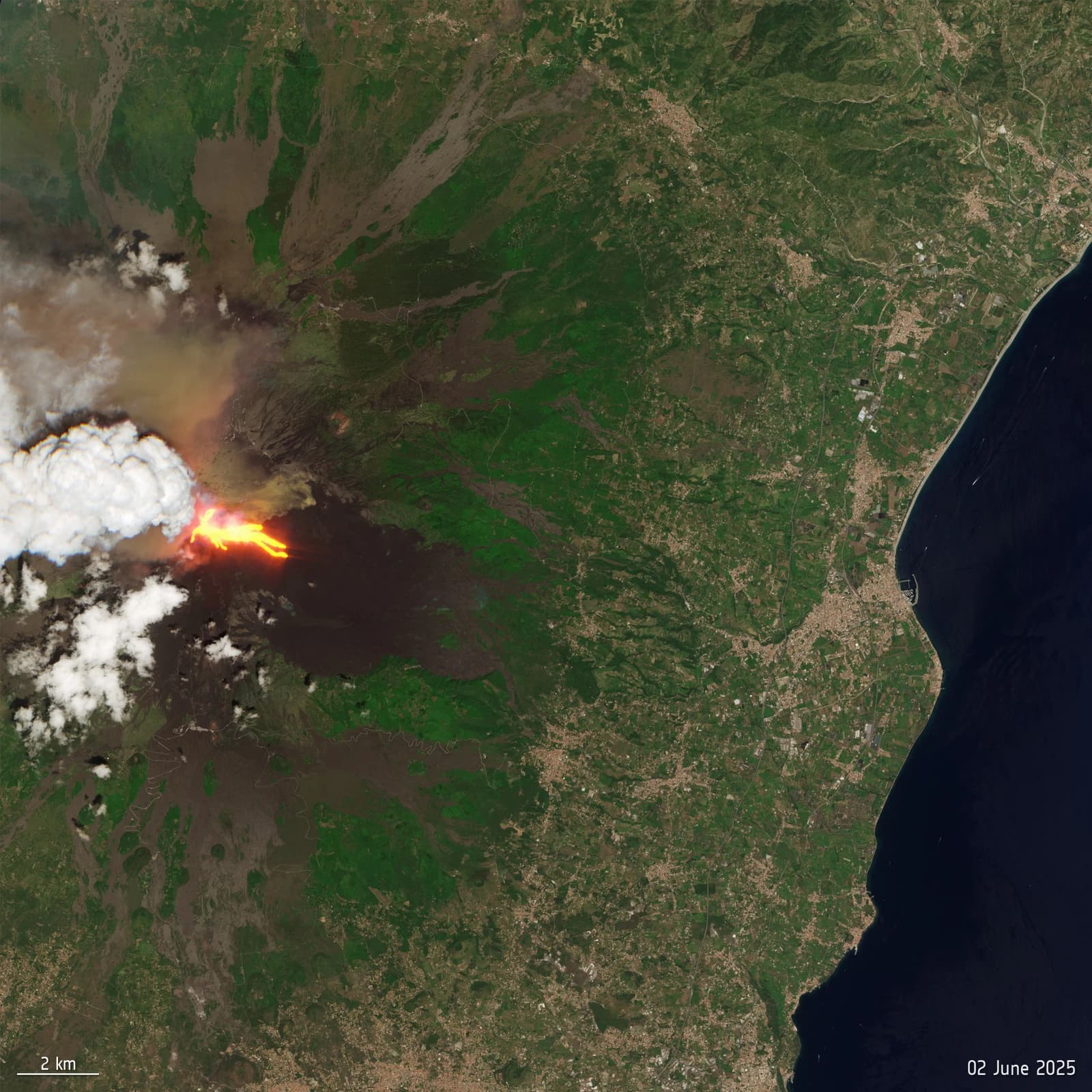 Satellite image of Mount Etna erupting, with visible lava flow, smoke plume, and ash spreading.