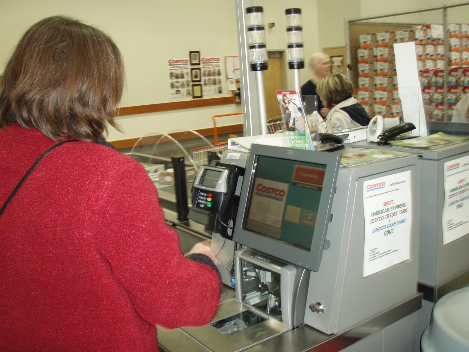 Woman uses a self-checkout machine at a Costco warehouse store.