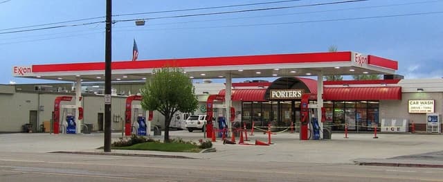 ExxonMobil gas station with red and white branding, gas pumps, and a convenience store.