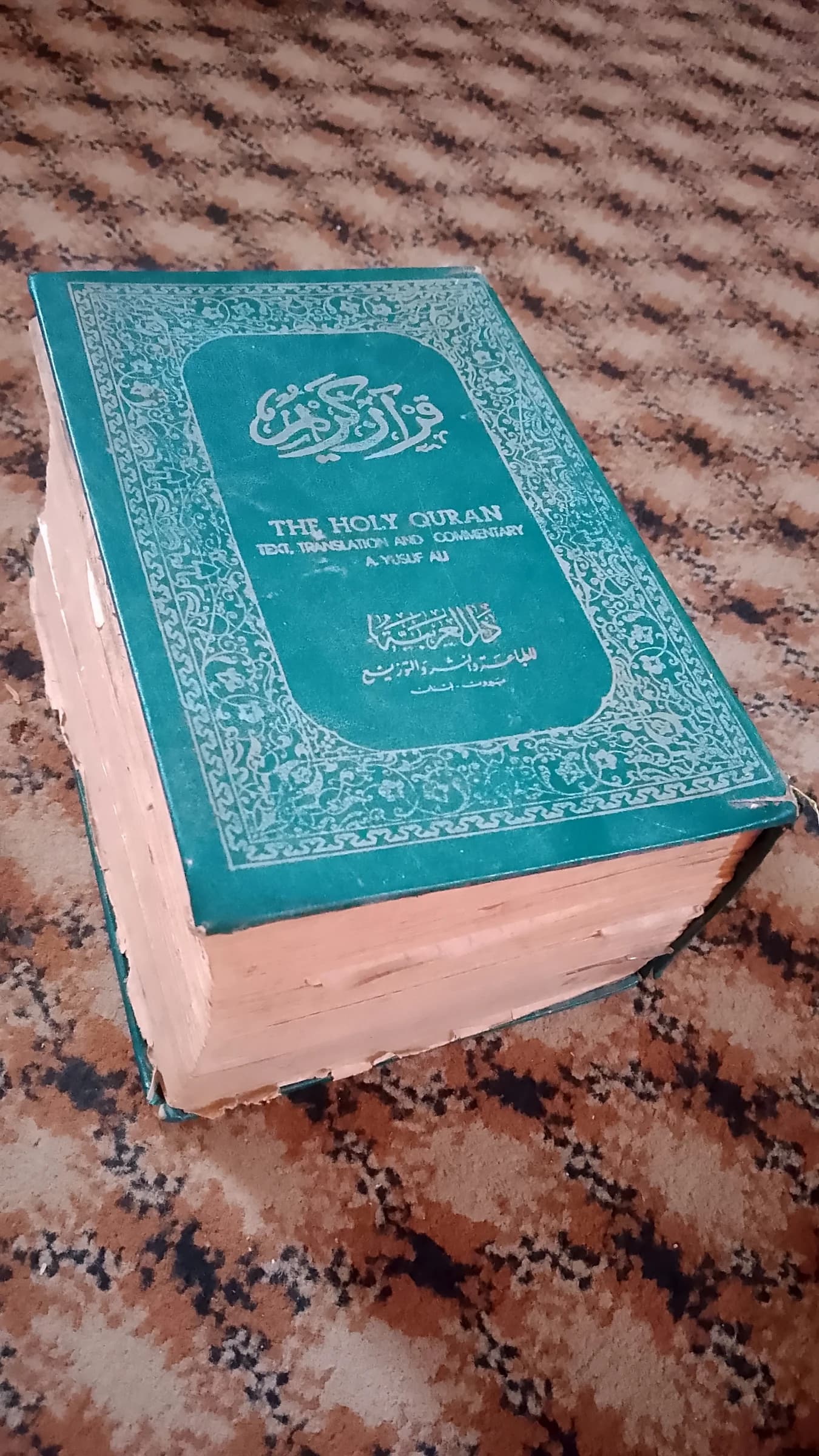 An old copy of Abdullah Yusuf Ali's translation of the Holy Quran.