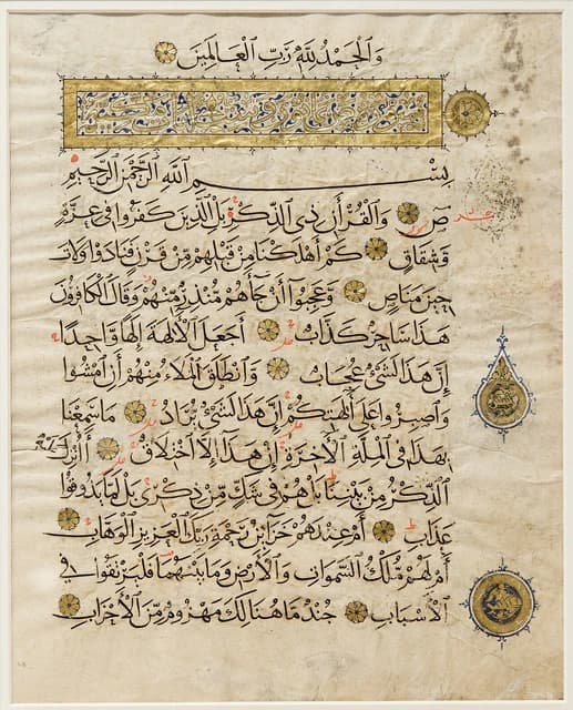 An ancient manuscript page of the Quran with Arabic script and gold decorations.