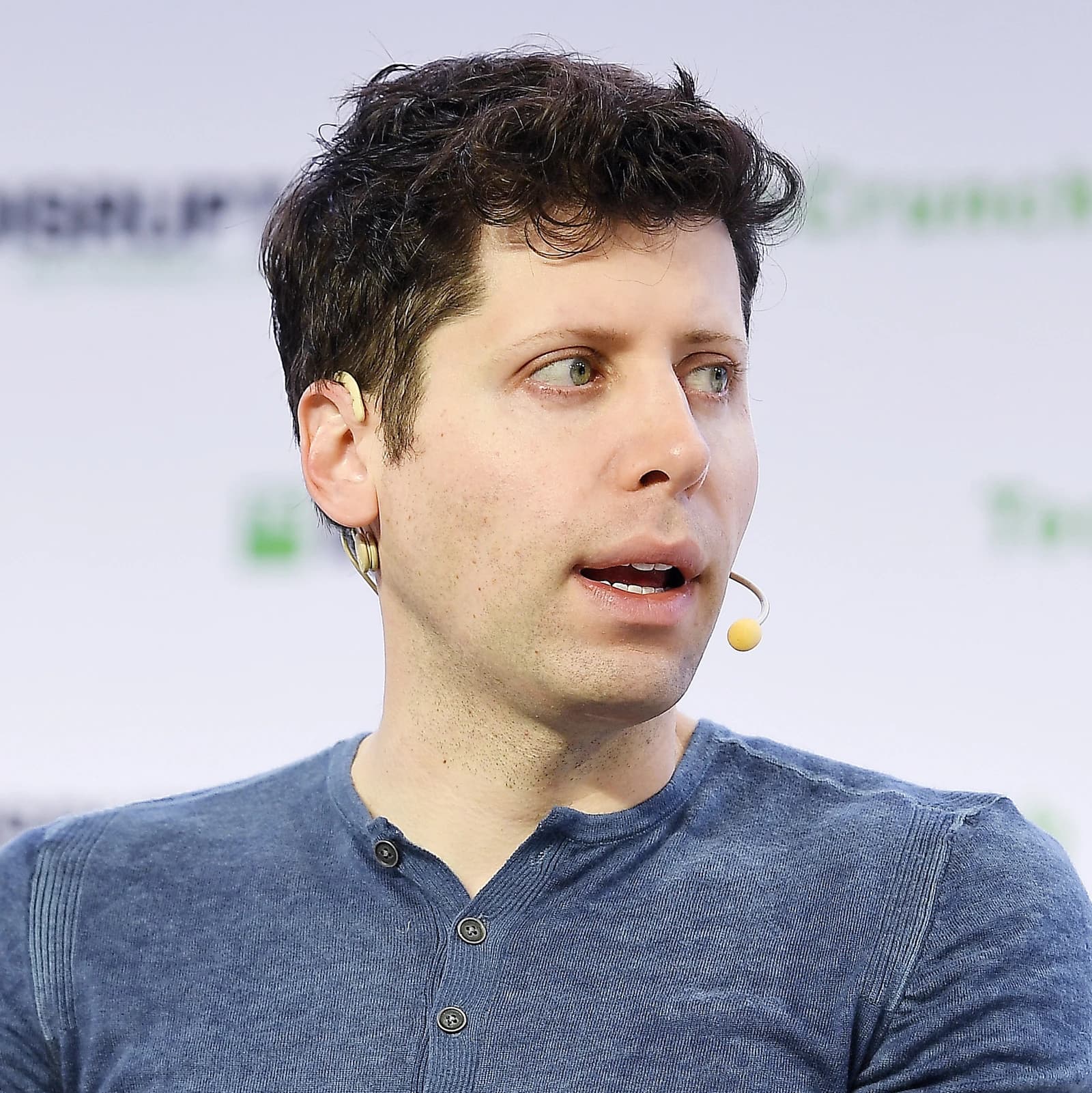 Sam Altman, OpenAI CEO, speaking at an event with a microphone.