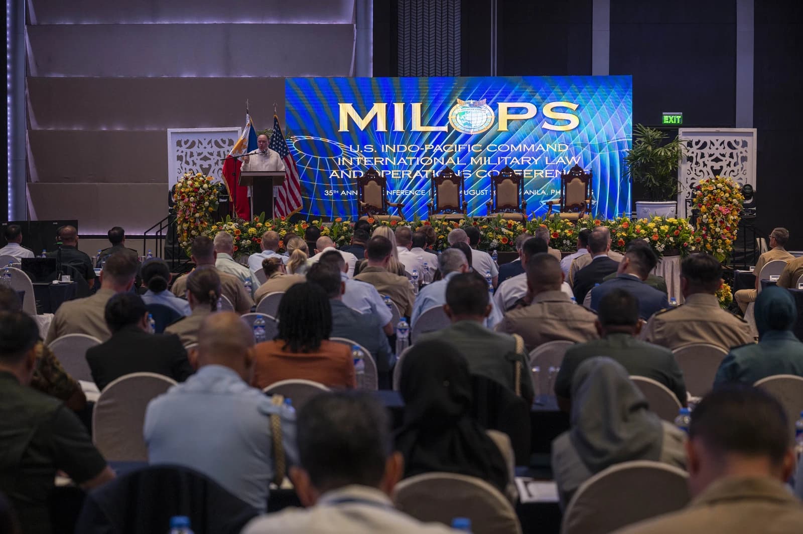 Man speaks at a podium to an audience at a U.S. Indo-Pacific Command conference.