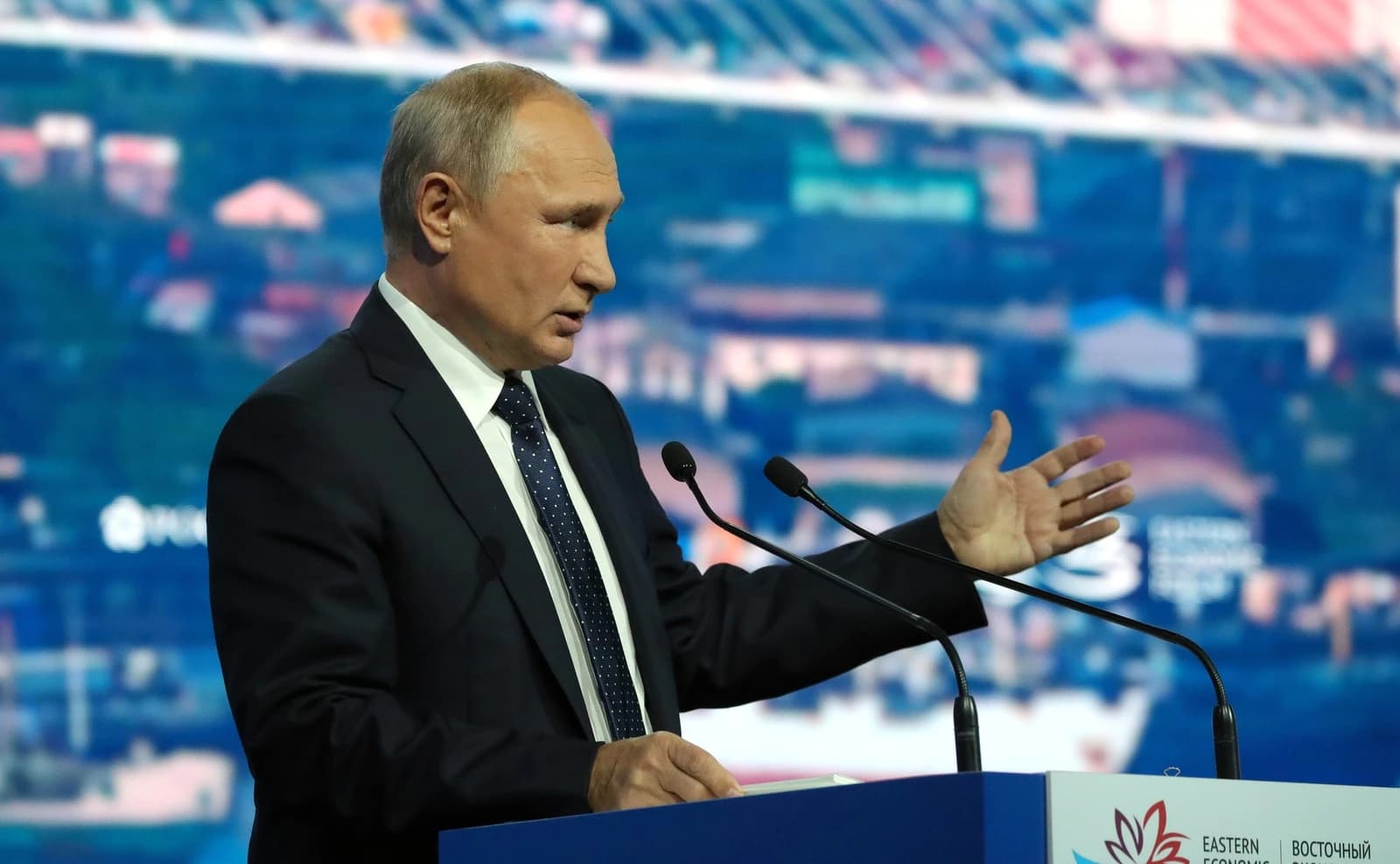 Vladimir Putin, Russian President, speaking at a podium with microphones.