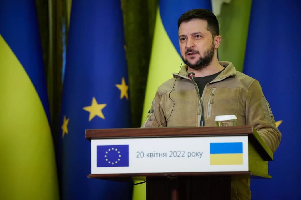 President of Ukraine Volodymyr Zelenskyy speaks at a podium with European Union and Ukrainian flags.