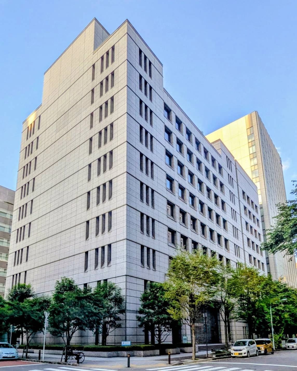 Exterior view of the Daiichi Sankyo Head office building with trees and street.