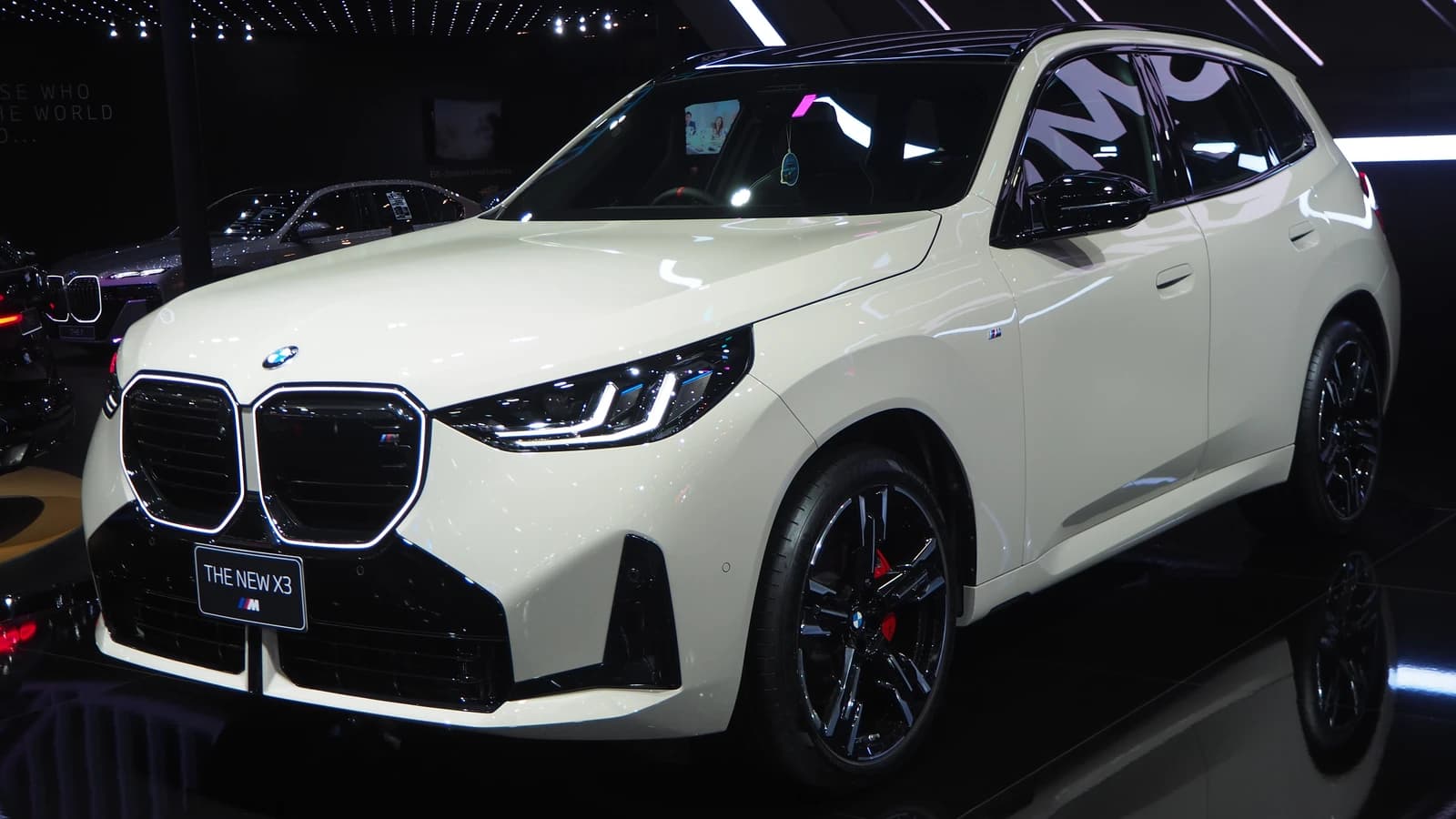 Front three-quarter view of a white BMW X3 M50 xDrive on display.