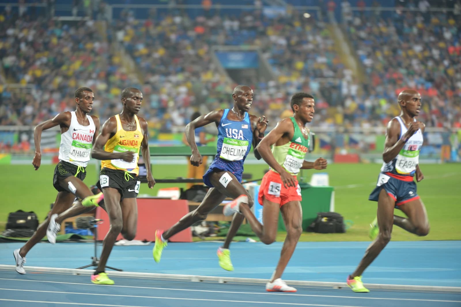 Paul Chelimo, wearing a blue USA uniform, running during a track race.