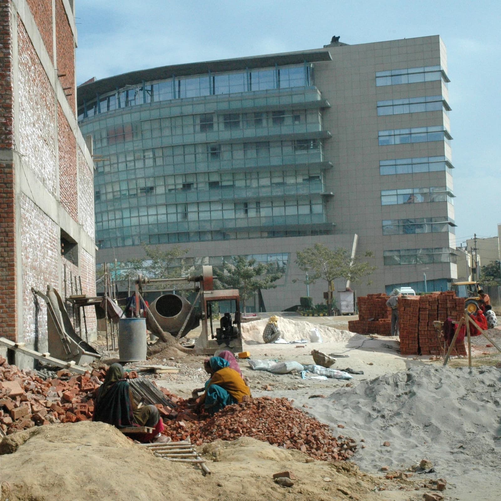 Construction workers sit among rubble and sand at a building site in Gurgaon, India.