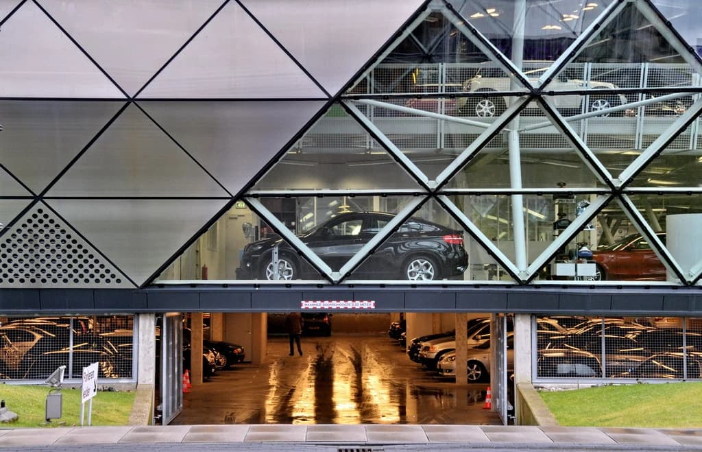 Modern building with a black BMW X6 SUV displayed through a glass facade.