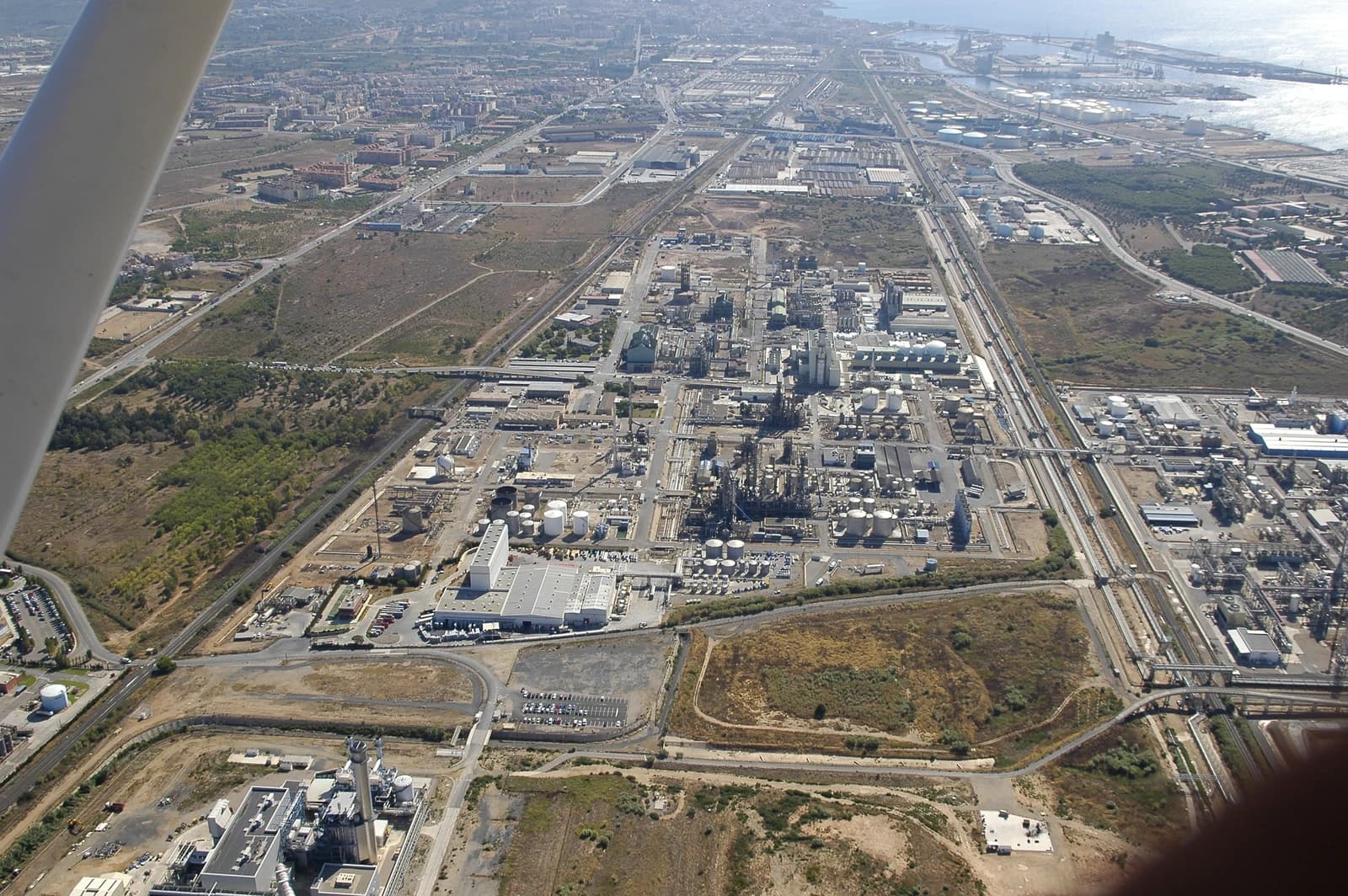 Aerial view of a large petrochemical complex with industrial buildings and storage tanks.