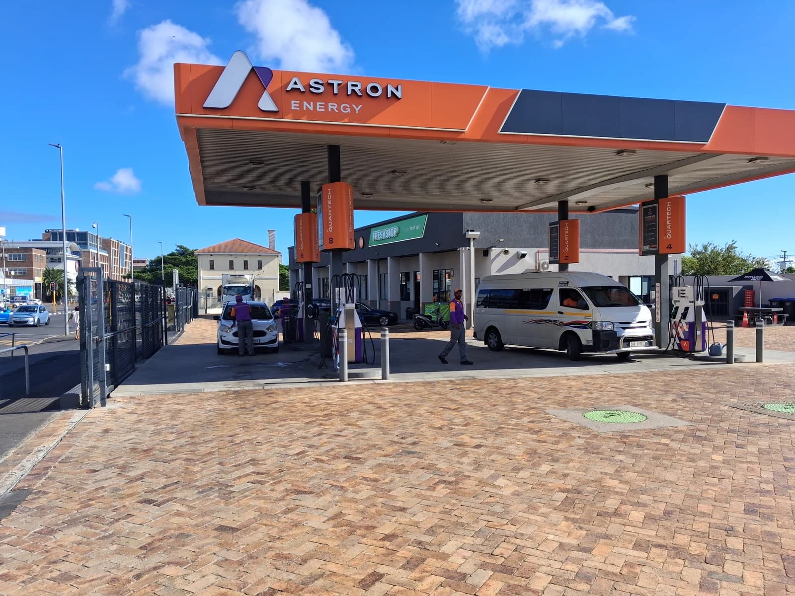 Astron Energy petrol station in Observatory, Cape Town, under a blue sky.