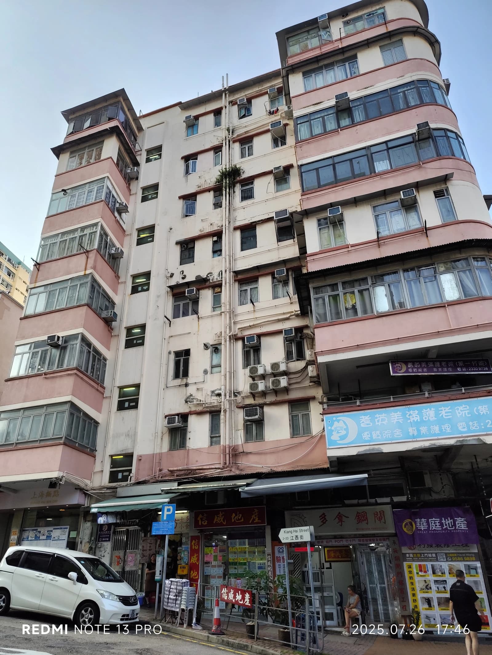 Tall residential building facade with multiple windows and balconies in Hong Kong.