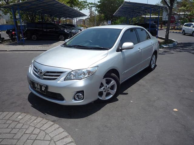 A silver 2012 Toyota Corolla Altis 1.8 G parked outdoors on a sunny day.