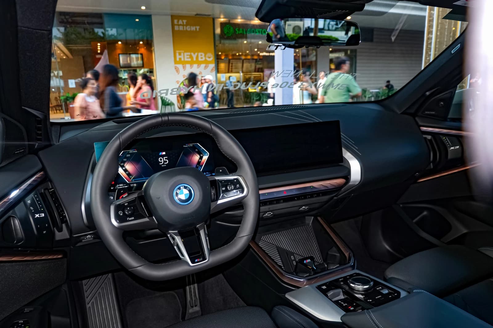 Interior of BMW X3 G45 xDrive30e PHEV with dashboard, steering wheel, and digital display.