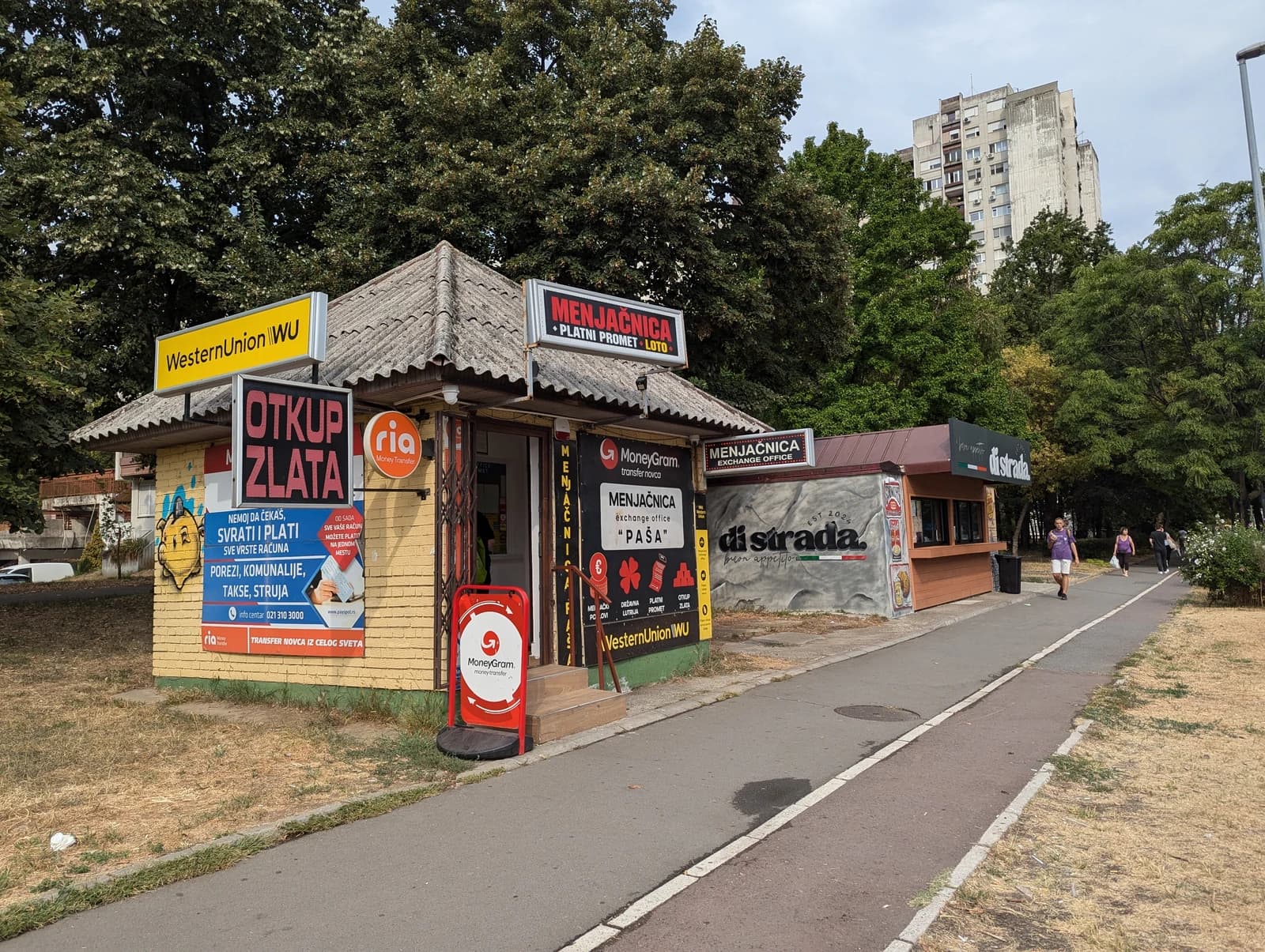 Currency exchange kiosks and other small businesses on Gandijeva Street in Belgrade.