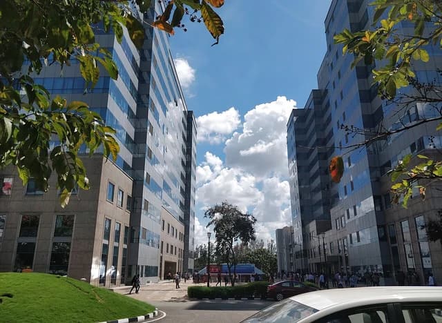 Modern office buildings with glass facades under a blue sky at International Tech Park in Bengaluru.