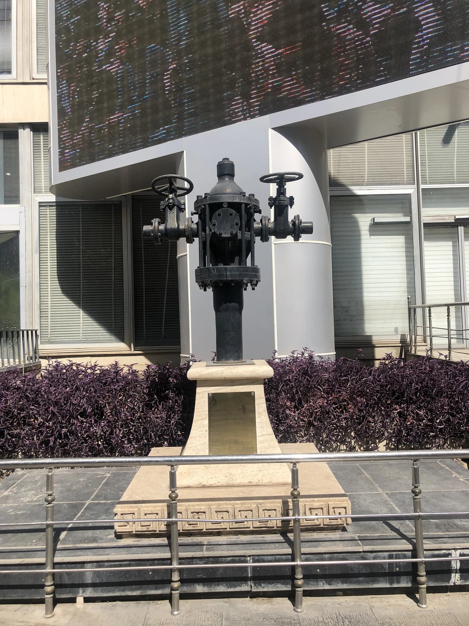 Entrance to the National Iranian Oil Company building with a dark metal sculpture.