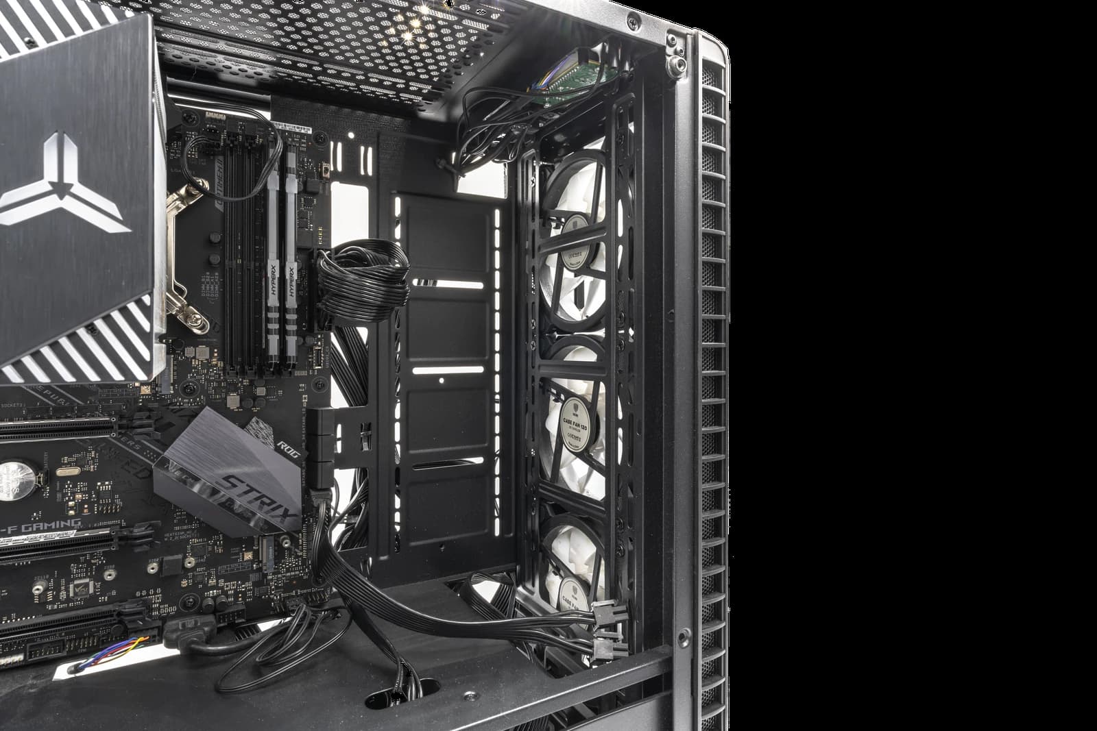 Internal view of a gaming PC motherboard, RAM, cooling fans, and wiring.