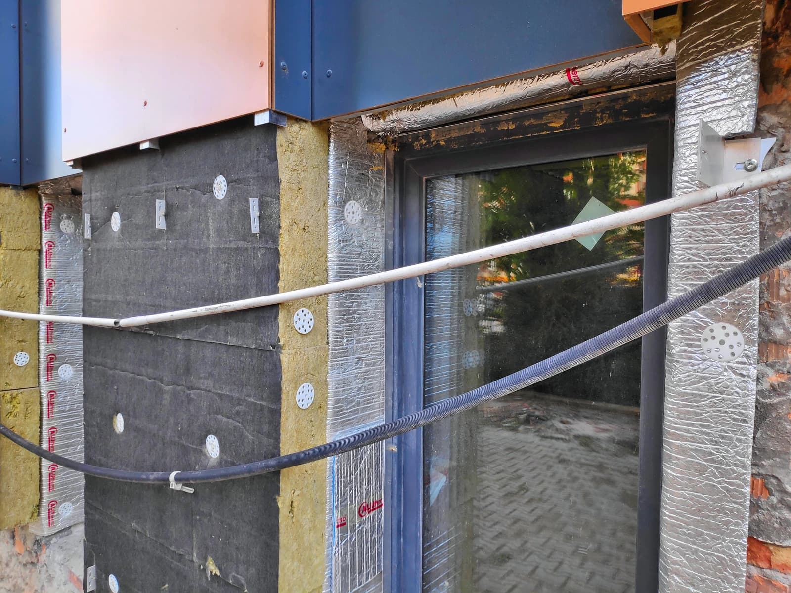 Mineral wool insulation and an aluminium composite mat applied to an exterior building wall.