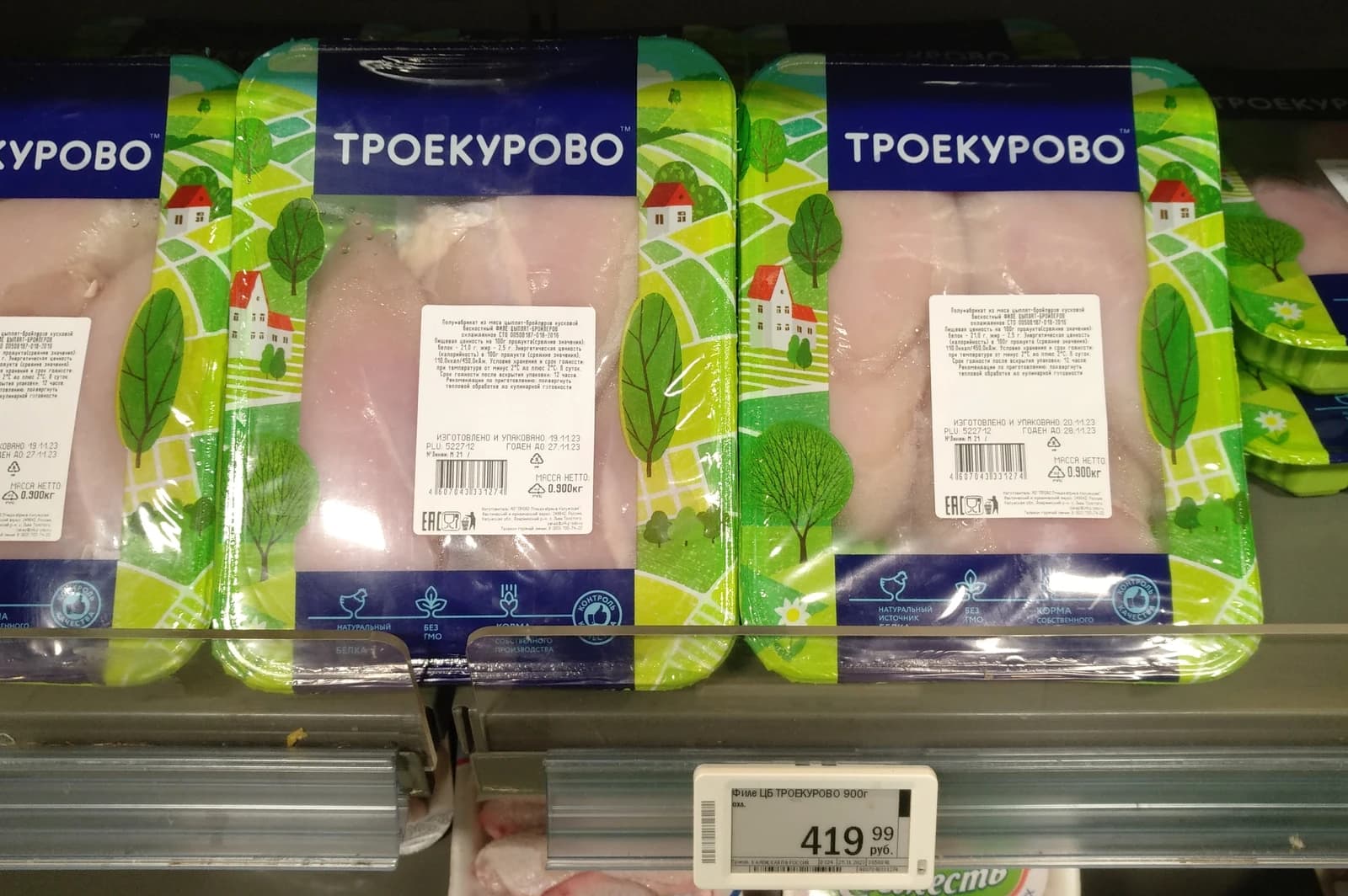 Packaged chicken fillets with Troekurovo branding and price tags in a refrigerated display case.