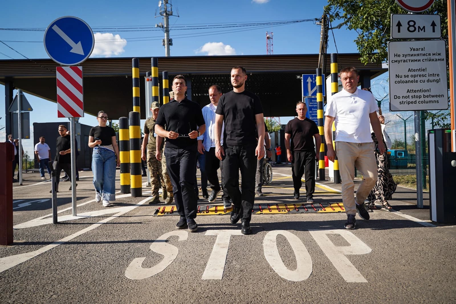 Mykola Kalashnyk, Ukrainian official, walks with a group through a border crossing point.