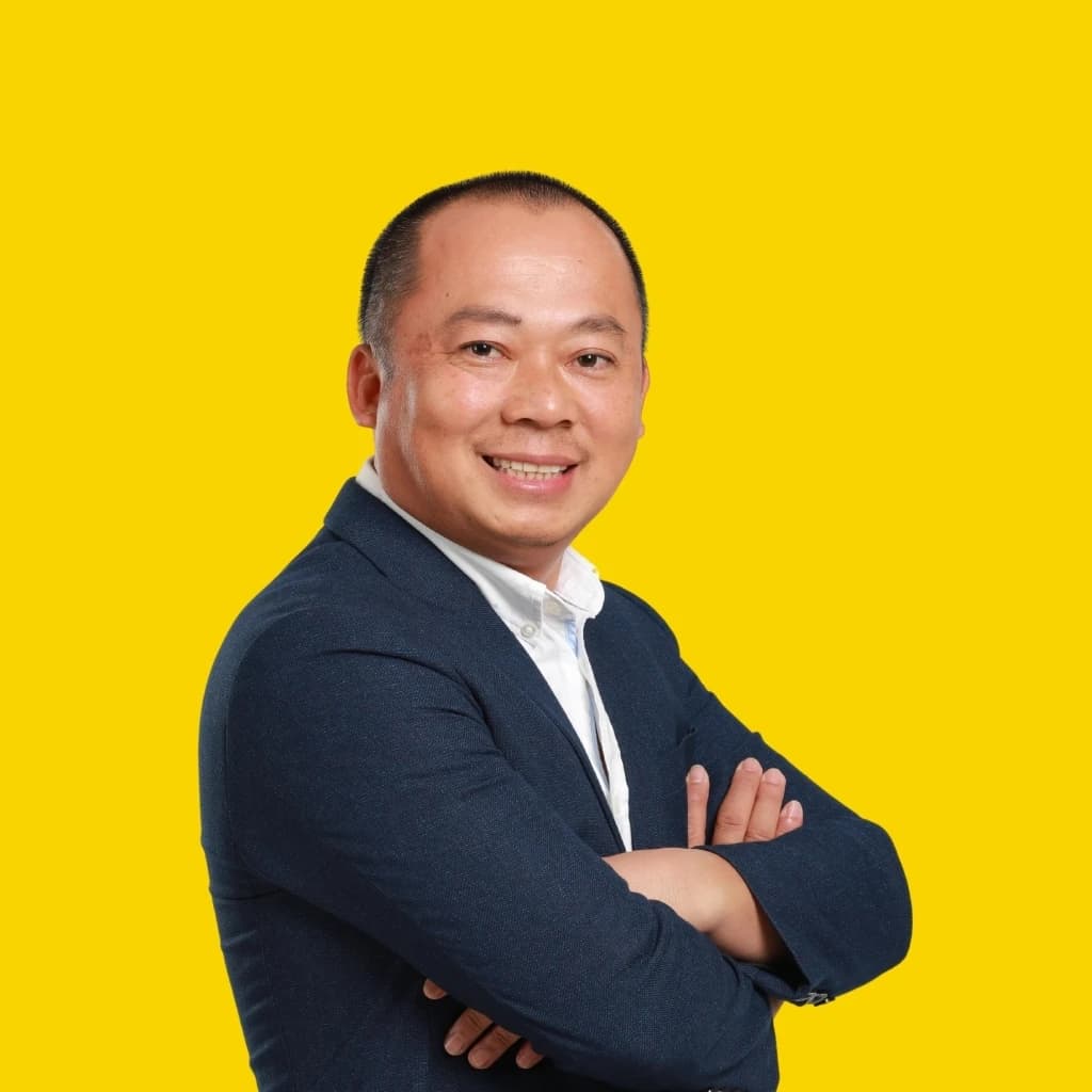 Doan Van Hieu Em, a man in a business suit, smiling at the camera.