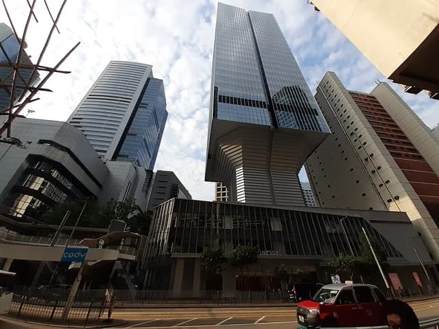 Modern skyscrapers and a red taxi on Hennessy Road, Wan Chai, Hong Kong.