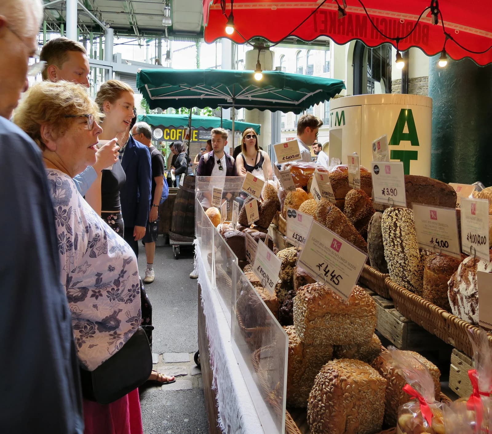 Customers browsing a stall with various loaves of bread for sale at Borough Market.