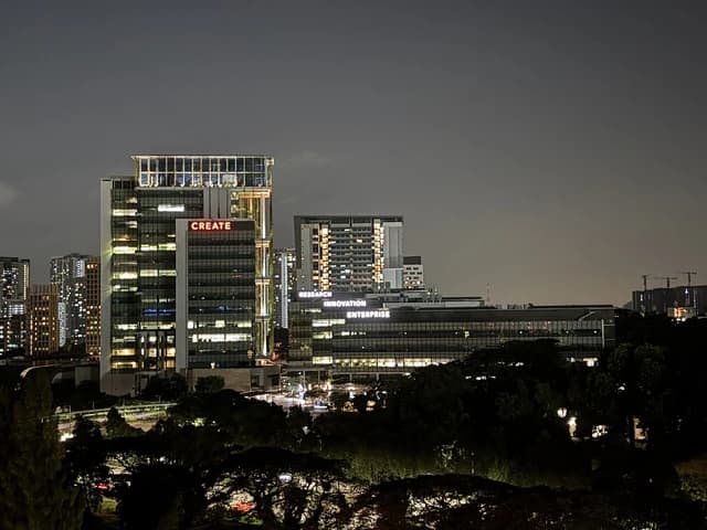 CREATE Tower and other buildings of National University of Singapore lit up at night.