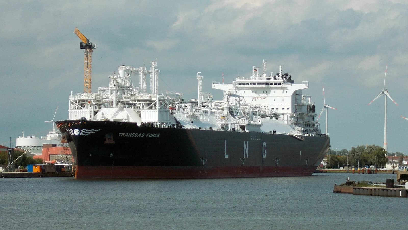 The Transgas Force FSRU ship, a large vessel for converting LNG, docked in a harbor.